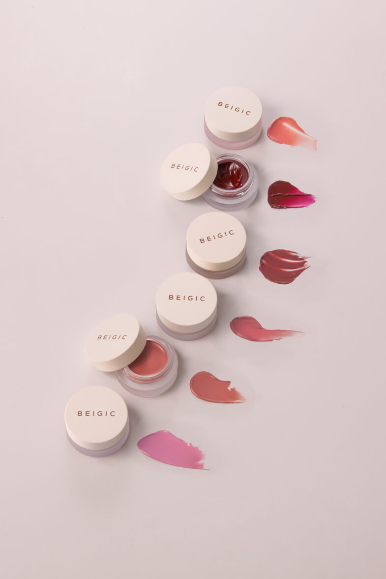 Five jars of BEIGIC cosmetics in various colors with corresponding smears beside them.