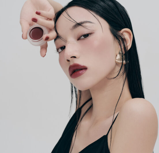 Žena nanosi ruž topli ton koristeći proizvod marke Divote Cosmetics, naglašavajući eleganciju korejske kozmetike.
