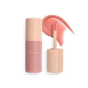 A pink lip gloss tube labeled "hince" with an open applicator and a swatch of the gloss beside it.